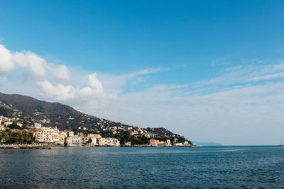 Scenic view of sea by buildings against sky