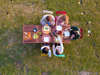High angle view of people sitting on grassy field