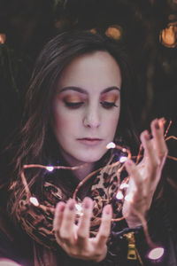 Close-up of beautiful woman holding illuminated lights