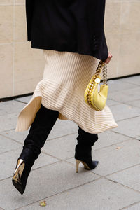 Low section of woman standing on street