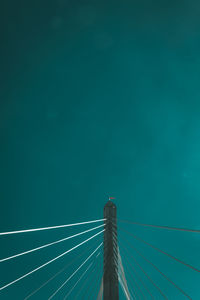 Low angle view of suspension bridge against blue sky