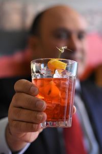 Close-up of man holding drink in glass