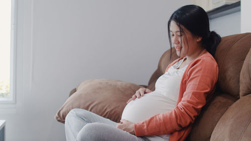 Woman sitting on sofa at home
