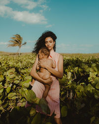 Portrait of woman standing on field against sky