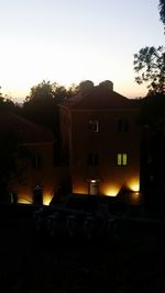 Illuminated buildings against clear sky at sunset