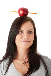 Close-up portrait of a smiling young woman against white background