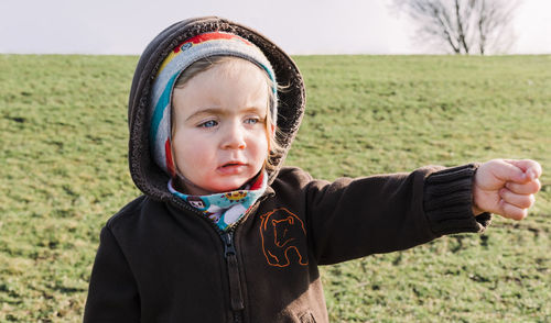 Portrait of cute baby girl on field