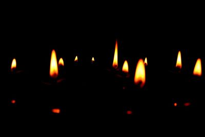 Close-up of lit candle in dark room