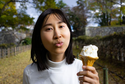 Portrait of young woman holding ice cream