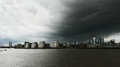 Buildings in city against cloudy sky