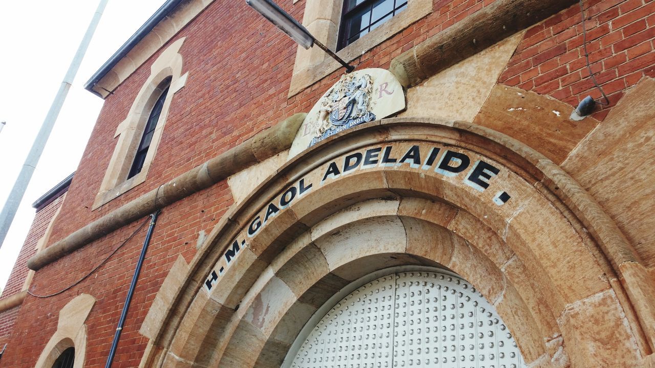 architecture, building exterior, built structure, low angle view, arch, window, building, brick wall, history, day, city, facade, text, outdoors, tower, no people, travel destinations, wall - building feature, architectural feature, famous place