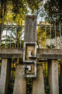 Low angle view of metal structure amidst trees and building