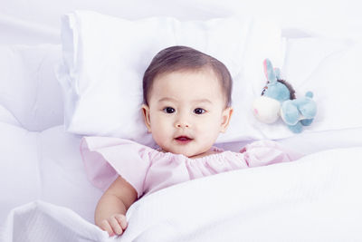 Portrait of cute baby lying on bed