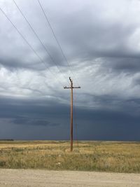 Electricity pylon on field against sky