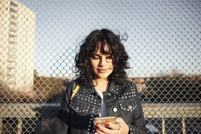 Smiling young woman using cell phone