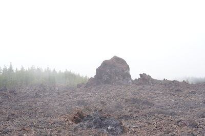 Rocks on landscape against clear sky