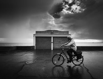 Side view of man riding bicycle on beach