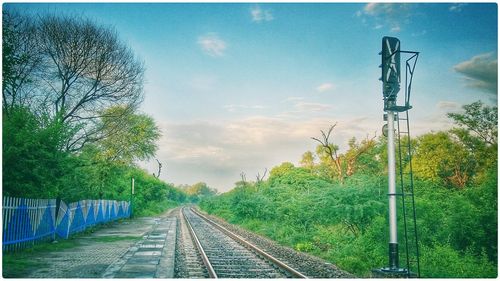 Railroad track against cloudy sky