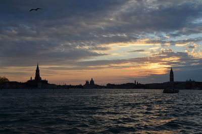 Grand canal against cloudy sky during sunset in city