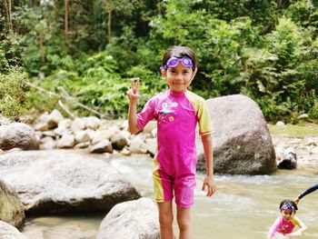 Portrait of smiling girl standing on rock