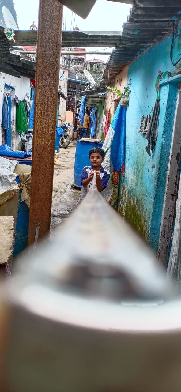 WOMAN STANDING ON A BOAT ALONG BUILDINGS