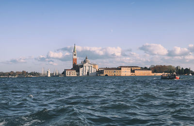 View of buildings by sea against sky