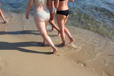 Low section of woman standing on beach