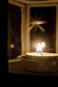 Close-up of lit candle in the dark