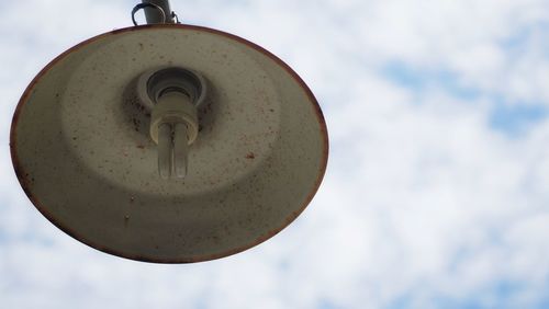 Low angle view of old electric lamp against sky