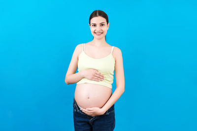 Portrait of a young woman against blue background