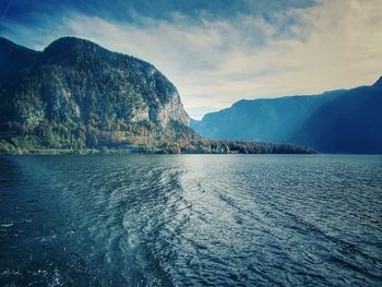 Scenic view of sea and mountains against sky