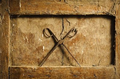 Close-up of rusty scissors on dirty wooden niche