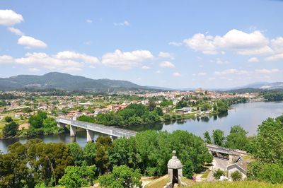 Rear view of people standing by river against sky