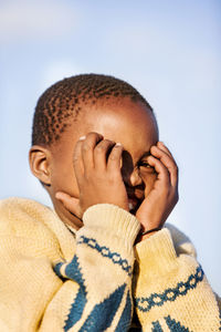 Close-up of cheerful boy against clear sky