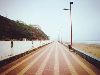 Road by sea against clear sky