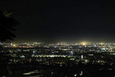 Illuminated buildings in city against sky at night