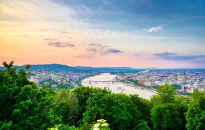 High angle view of river and cityscape against sky at sunset