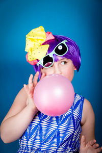 Portrait of boy holding toy against blue background