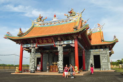 People outside temple against building