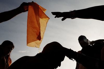 Low angle view of hand against sky during sunset