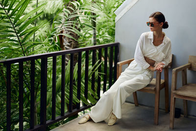 Portrait of young man sitting on railing