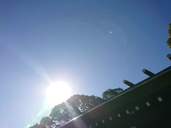 Low angle view of buildings against blue sky on sunny day