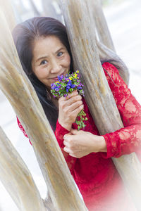 Portrait of smiling woman holding plant