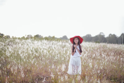 Woman standing on field against sky