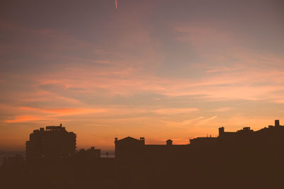 Silhouette town of benalmadena against sky during sunset