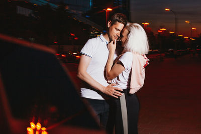 Couple kissing while standing outdoors at night