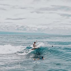 Man surfing in sea against sky