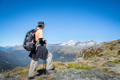 Rear view of man looking at mountain against sky