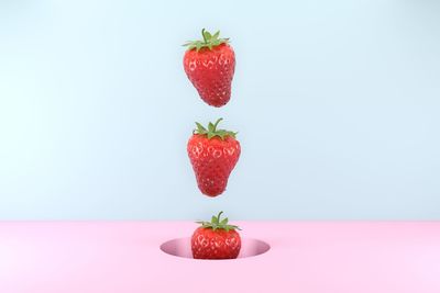 Digital composite image of strawberries over colored background