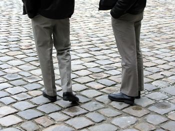 Low section of people standing on cobblestone